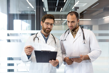 Doctors discussing patient's medical history in hospital corridor