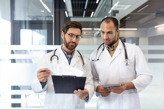 Doctors discussing patient's medical history in hospital corridor