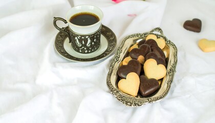 Heart-shaped cookies with coffee on a white cloth