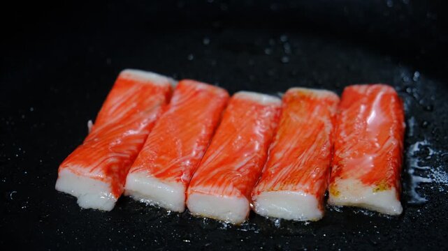 Kanikama. Snow crab immitation, surimi sticks frying. Iron cast pan. Seafood