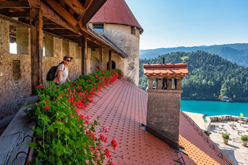 Tourist woman enjoying the stunning views of Lake Bled seen from the castle, Slovenia.