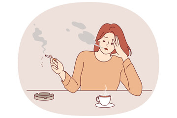 Woman smokes cigarette and drinks hot coffee from cup, sitting at table taking break after difficult work. Stressed girl suffering from tobacco addiction and habit of caffeine for energy.
