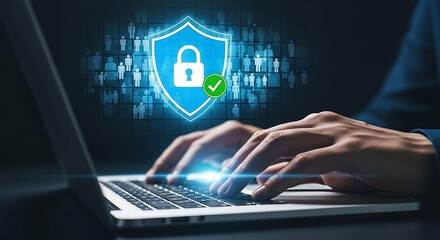 Cybersecurity concept with a glowing blue shield icon featuring a padlock and checkmark overlayed on a person typing on a laptop with a digital data background