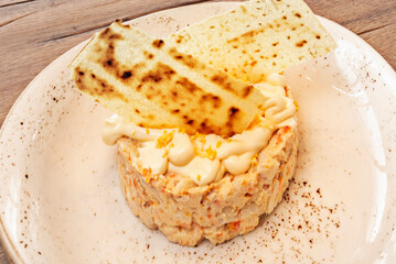 Seafood Russian salad with mussels, shrimp, and potato, tossed with mayonnaise aioli and garnished with parsley and paprika.