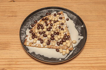 Dark chocolate crepes folded into triangles with a chocolate cream and candied orange filling, topped with chocolate sauce.