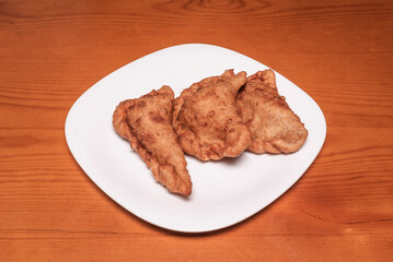 Desalted cod empanadas cheese, wheat flour dough, and beer, accompanied by roasted peppers