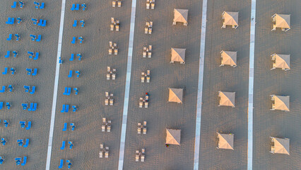 Sun umbrellas and sun loungers on the beach, Tyrrhenian Sea, tourist resort of Viareggio, Italy. View from above