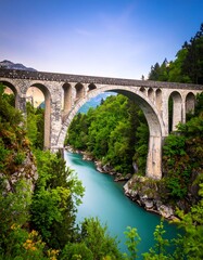 Majestic arch bridge over a turquoise river, nestled in a lush valley