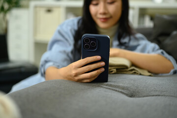 Young woman using smartphone, checking travel plans and preparing for her trip