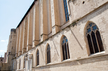 Religious complex of Santa Clara (St. Clare) with basilica, monastery, tombs, museum. Naples, Italy.
Lateral tufa brickwork fa&ccedil;ade of the church and monastery with mullioned or triple lancet windows. 