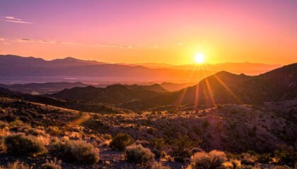 Desert sunset over layered mountain ridges and dry terrain