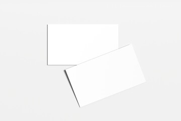 Two blank, rectangular business cards are arranged in an overlapping diagonal pattern on a light gray background