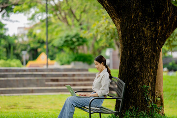 Fototapeta premium Teenage student outdoors with laptop and earphones, reading, studying, learning online, enjoying music, communication, cyberspace, education, happiness. 