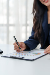 Businesswoman analyzing financial charts and graphs in office