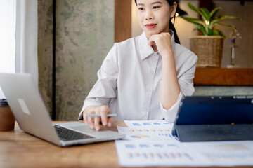 Professional businesswoman working at office desk with laptop, analyzing financial data, showcasing leadership, motivation, corporate expertise, and entrepreneurial confidence.
