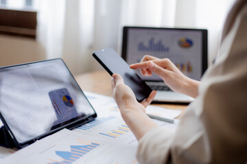 Confident businesswoman working at desk with computer in office, smiling while focusing on tasks, symbolizing success, motivation, persistence, and professionalism.
