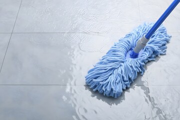 Blue microfiber mop cleaning wet floor.