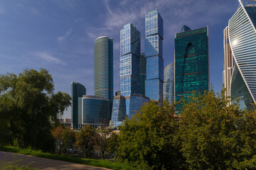 Obraz premium High-rise buildings and skyscrapers on a sunny summer day. Sunbeams and glare on the buildings