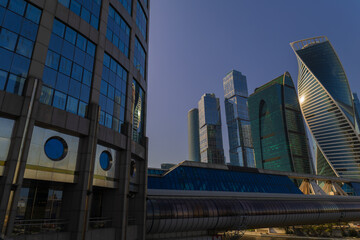 Naklejka premium Cityscape on a summer day, modern buildings and houses against the blue sky 