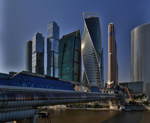 Naklejka premium Cityscape on a summer day, modern buildings and houses against the blue sky 