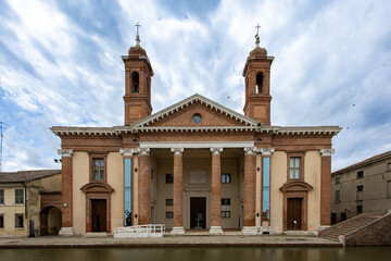 Obraz premium Comacchio, Italy 08 24 2025 Museo Delta Antico neoclassical facade with twin bell towers, grand columns and canal view, historic landmark in the heart of Emilia Romagna’s old town.