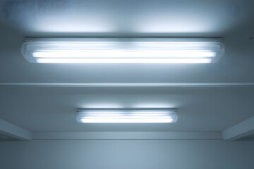 Fluorescent ceiling lamp illuminated in modern interior.