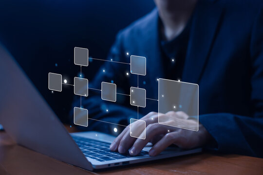 Businessman using a laptop. a flowchart hologram, symbolizing workflow automation, process management, digital transformation, data organization, system integration, and business efficiency.