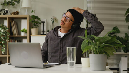 Asian man is stretching his body after working at home.