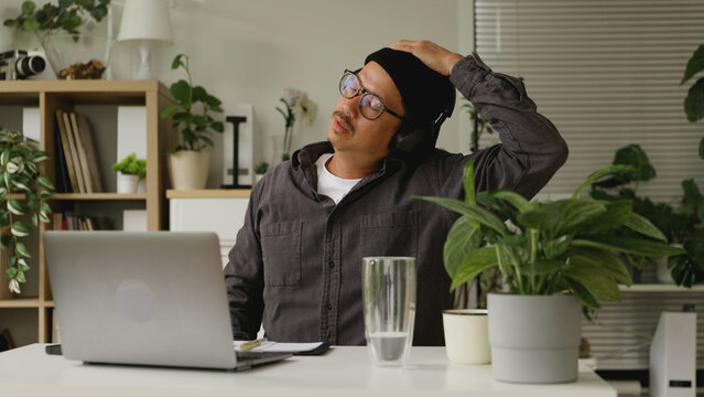 Asian man is stretching his body after working at home.