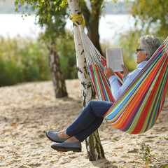 Tranquil Autumn Escape: Senior Reading by the Lake