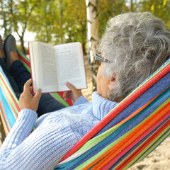 Peaceful Autumn Moments: Senior Relaxing in a Hammock by the Lake