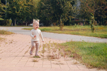Fototapeta premium Little girl walking outdoors, cheerful child enjoying happy summer childhood in fresh air 