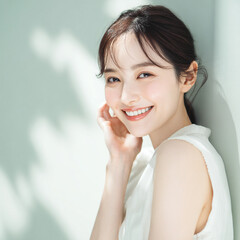 笑顔できらめく綺麗な肌と白い歯を見せる日本人女性美人モデルの接写写真。オーラルケア、スキンケア、コスメ広告用。