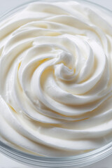 Glass bowl of sour cream swirl close up detail against white background. Recipe preparation and cooking concept.
