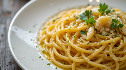 Close-up shot of a plate of spaghetti aglio e olio, a classic Italian pasta dish, garnished with parsley and garlic.