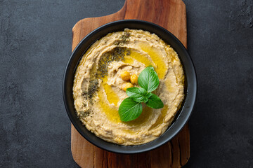 A traditional dish or appetizer hummus or baba ghanoush on black  background