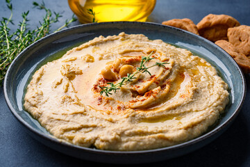 A traditional dish or appetizer hummus or baba ghanoush on black  background