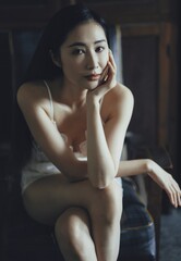 Woman in white sleepwear sitting gracefully with a serene expression.