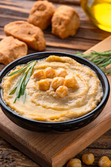 A traditional dish or appetizer hummus or baba ghanoush on wooden  background