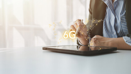 A business professional uses a digital pen on a tablet, with a glowing 6G symbol and global connection graphics floating above the screen, representing future wireless technology innovation.