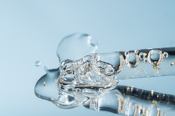 Bottle pipette dropper close up and Liquid yellow-orange retinol or vitamin c gel or serum on a...