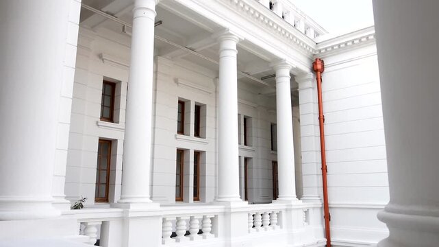 Slow Motion Pan of a White Dutch Colonial Building with White Columns and Classical Architecture in an Elegant Building. Aesthetics of Historic Architecture