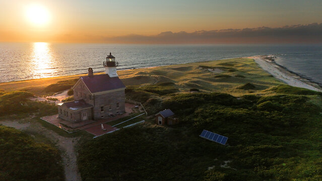 Aerial view of Block Island North Light stands majestically against the setting sun, its stone facade a testament to time and tide, New Shoreham, Rhode Island, United States.