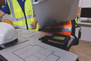 Closeup of team of industrial engineers meeting analyze machinery blueprints consult project on...