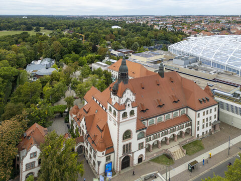 Aerial view of the historical building with red roofs contrasting against the lush green trees of Zoo Leipzig, Leipzig, Saxony, Germany.