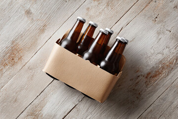 Four brown bottles in a cardboard carrier on rustic wood. Symbolizes refreshment, gathering, and relaxation. Great for beverage, party, or social event themes.