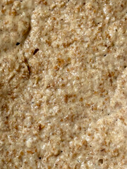 Macro closeup of bubbly sourdough starter with brown and beige fermentation texture, organic homemade baking, bread preparation, and healthy kitchen background