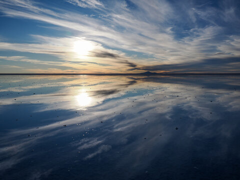 Horizontal landscape picture of Salar de Uyuni with mirror effect, picture taken against the sun