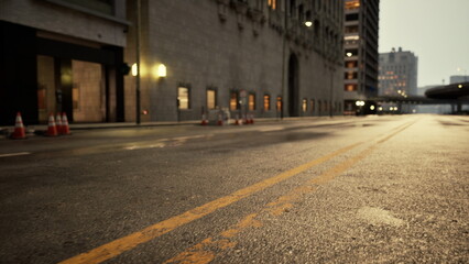 As twilight descends, the urban streets glisten with moisture while lights gently illuminate buildings. Traffic cones mark a construction zone, hinting at the citys ever evolving landscape.
