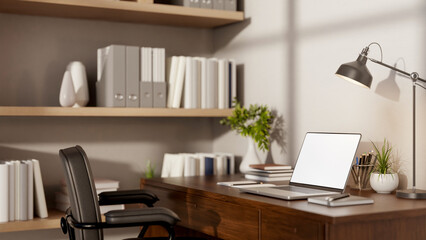 White screen laptop with book and stationary aside metal lamp on wooden table and leather armchair. © bongkarn